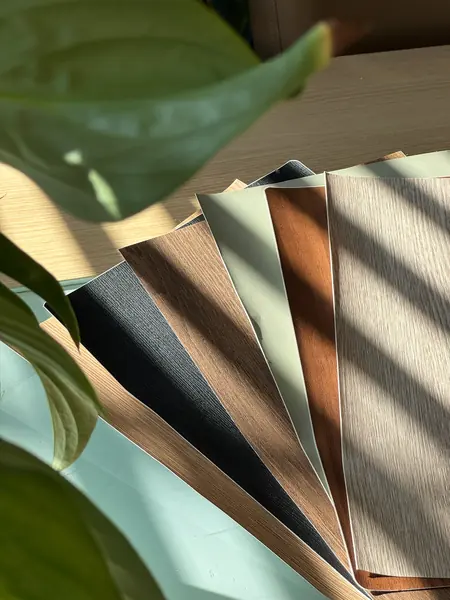 Kleursamples in houtlook en effen kleuren op tafel in het zonlicht
